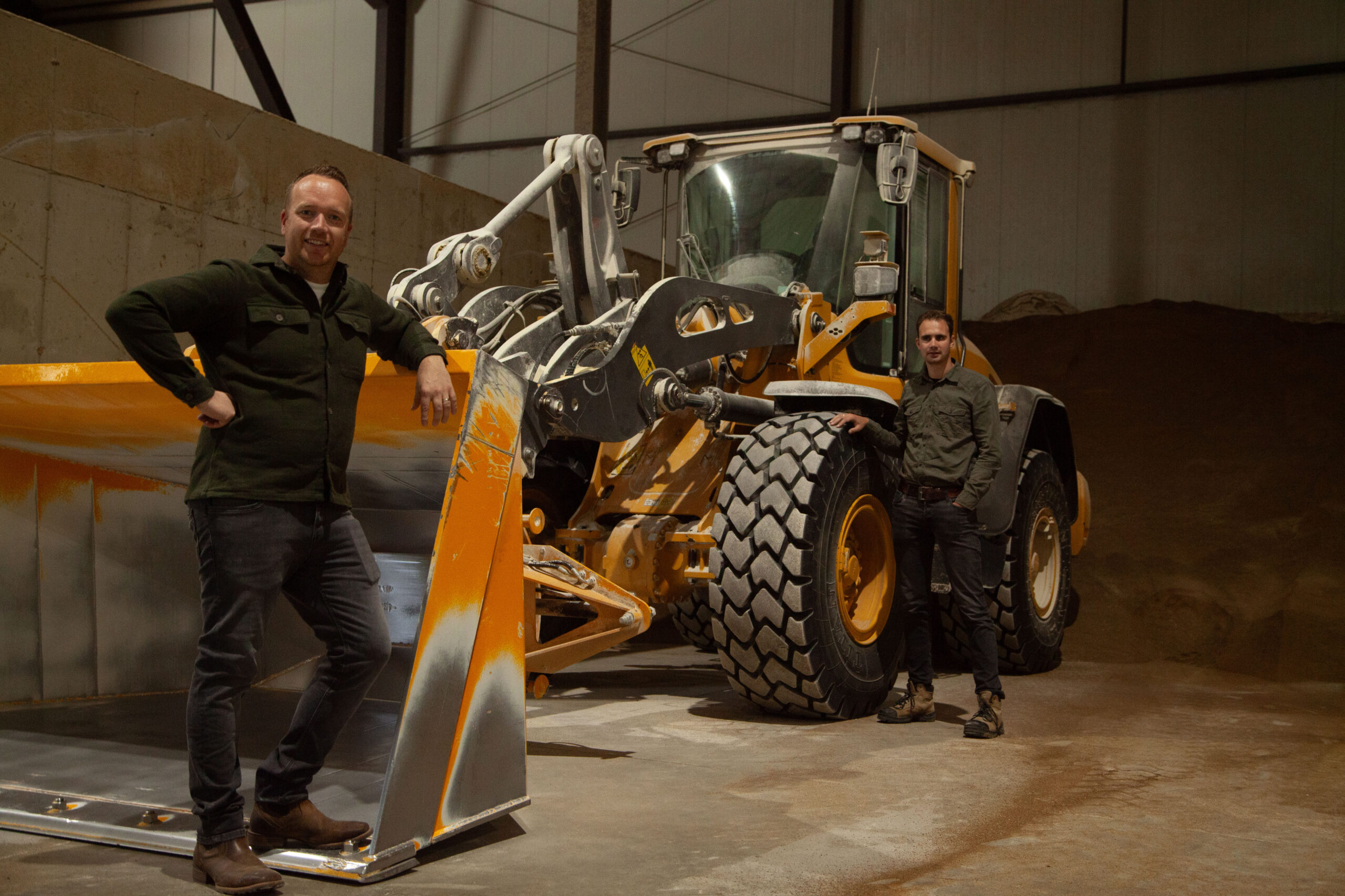 Soulstone feed staff standing next to dumper equipment in warehouse